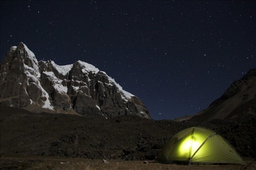Trekkers try and escape the deathly cold of the night inside their tent huddled under the giants of the Andes – Cordillera Huayhuash, Peru
