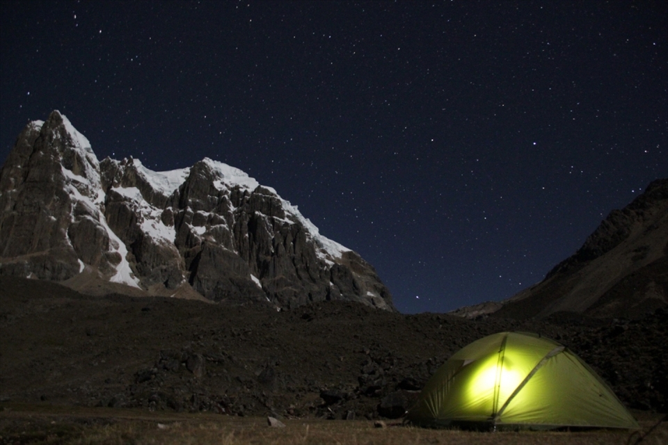 Trekkers try and escape the deathly cold of the night inside their tent huddled under the giants of the Andes – Cordillera Huayhuash, Peru
