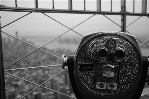 It's name was created from the nickname “Empire State” given to New York. As the worlds tallest building with a height of  381 m from 1931 till 1972 it symbolized New York's commerce and excellence in architecture. New York was trying to catch the worlds attention. 
 The idea behind my picture is to invite the viewer to use the binoculars for a clearer view of New York's skyline. 
