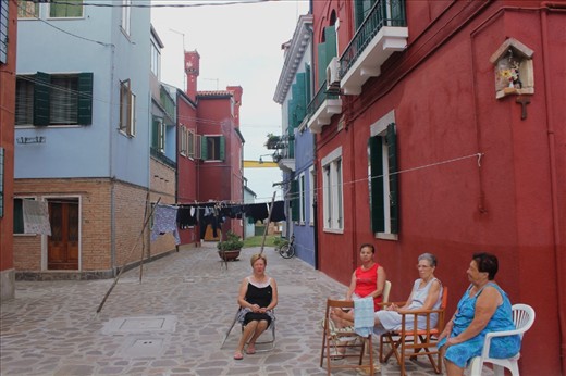 As the day draws steadily to its close, Burano women discuss parochial matters outside their houses. Meanwhile, washing lines lean this way and that, their form echoed metres above them by communication wires. When everyone has clothes to dry, I presume the wires double up as washing lines.