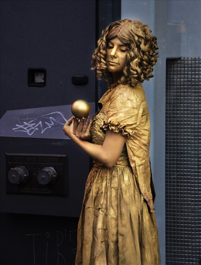 In the midst of busy Granville Street, twirling and manipulating a golden sphere, is a street performer named Dawn. Though she appears peaceful, this image was preceded by a series of twist and turns manipulating the sphere in such a way that it revolves around her body then alas,  the spiral ends. It is a micro-cosmic reflection of the wider world and the universe. An example of action and reaction, and that as the juggler controls the sphere, we can control our destiny. 