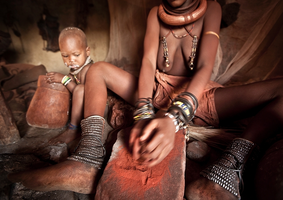 Once the women are feeling fresh again after their fragrant smoke bath they set about grinding down small stones of ochre. Rhythmically the women work away grinding the red stones down into a very fine powder.