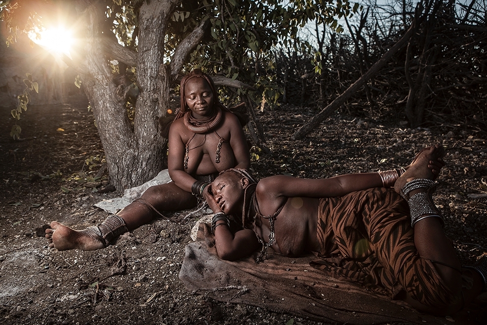 The process of reapplying the hairs casing usually takes a whole day and soon the women begin to get restless. The final process is a skilful and delicate one which only a few can master, but as the sun begins to set on another day so does the hardening ochre in the final stages of the the Himba beauty salon.
