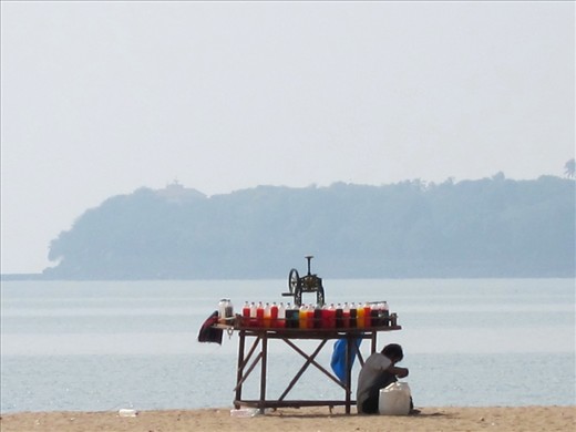 The 250,000 street vendors of Mumbai are a part of the urban poor that has moved on to create jobs for themselves with minimal capital, instead of depending on the indifferent government to help them.  Experts estimate that the ‘informal’ economy from businesses such as street-vending contributes significantly towards the country’s annual economic growth and is responsible directly or indirectly for as much as 90% of all employment. Seen here hiding from the midday sun on the heavily polluted Chowpatty beach, is a “gola” (slush) vendor.