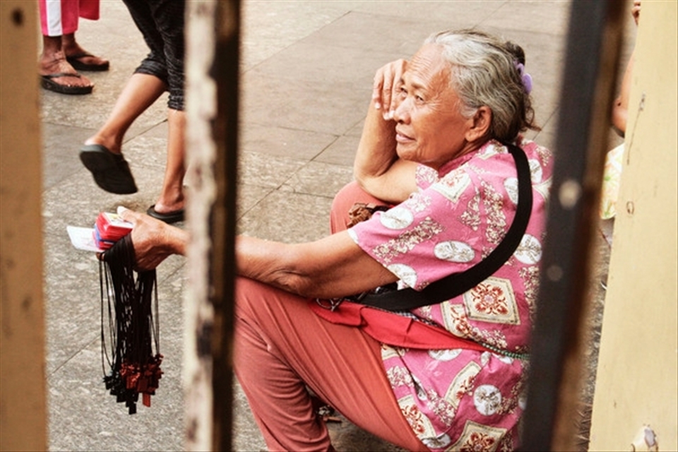 This woman is taking a rest after a long day of selling booklets and scapulars by the church steps. 