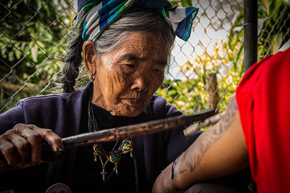 There were about 20 travellers who came and left when I was in Kalinga. They all came to get tattoos from Fang-Od. The tattoo is done using two bamboo sticks, one of which has a thorn attached to it while the other is used for tapping. The ink is made of soot. This is a photograph of her giving a tattoo to one of the travelers who came to visit her. 