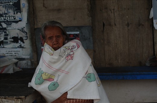Lady sitting outside of market - 2012
