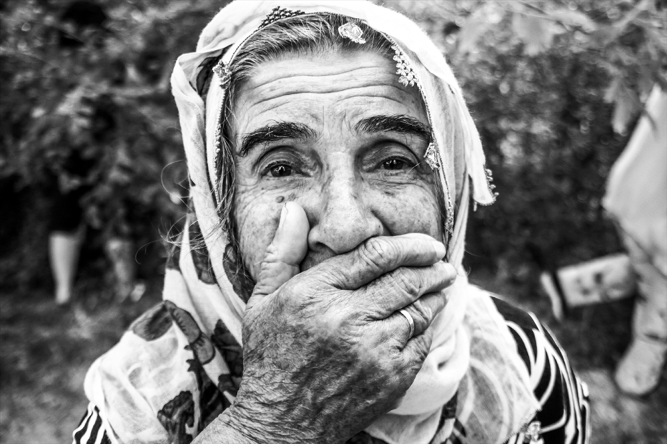 This is my grandmother.A portrait of her, while they are picking up mulberries. My grandma is the oldest member of the street after  'Bodo'. She does not like my photos I took her and I always think that she is still not ready to see herself, her senescence and  wrinkles which are the marks of her pains in her face and hands. Two husbands who died before her and leave alone, that's why tears and smiles merge in her eyes always. 