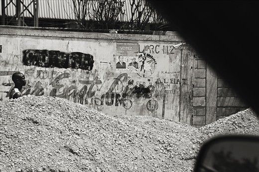 After the earthquake in Haiti, the rebuild was a long, slow process.  Roads were lined with construction material, garbage and rubble for months after the disaster. Here a man walks roadside barely visible over the piles.