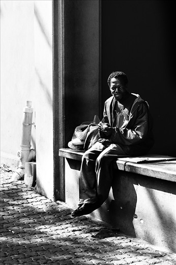 Homeless people are common in South Africa, at traffic lights and on street corners. This homeless man was not bothered by the camera. he smiled afterward and said thank you to me. 