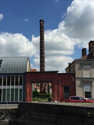 Brugge -- street scene of old brick smoke stack across canal