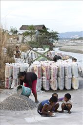 While the kids are busy playing and sharpening a stone as their toy, Ailyn, 24, is piling up the sorted stones before putting them in sacks, ready for sale and pickup by costumers.  The smallest stones cost 25 Philippine Peso (PHP25.00) or approximately half a dollar (USD0.50) per sack and the bigger stones cost even lower. She said, “Proceeds from the gathered stones are just enough to make both ends meet for the family.”: by bingtajon, Views[683]