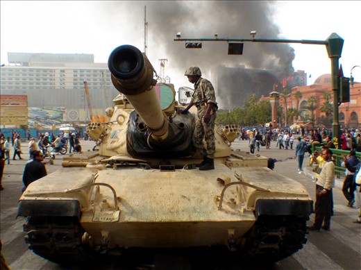 The military deploys to the city but waits for days to hear which side they will take.  A tank in Tahrir square, the ruling political party's headquarters burns behind for three days, next to the Egyptian National Museum.  
