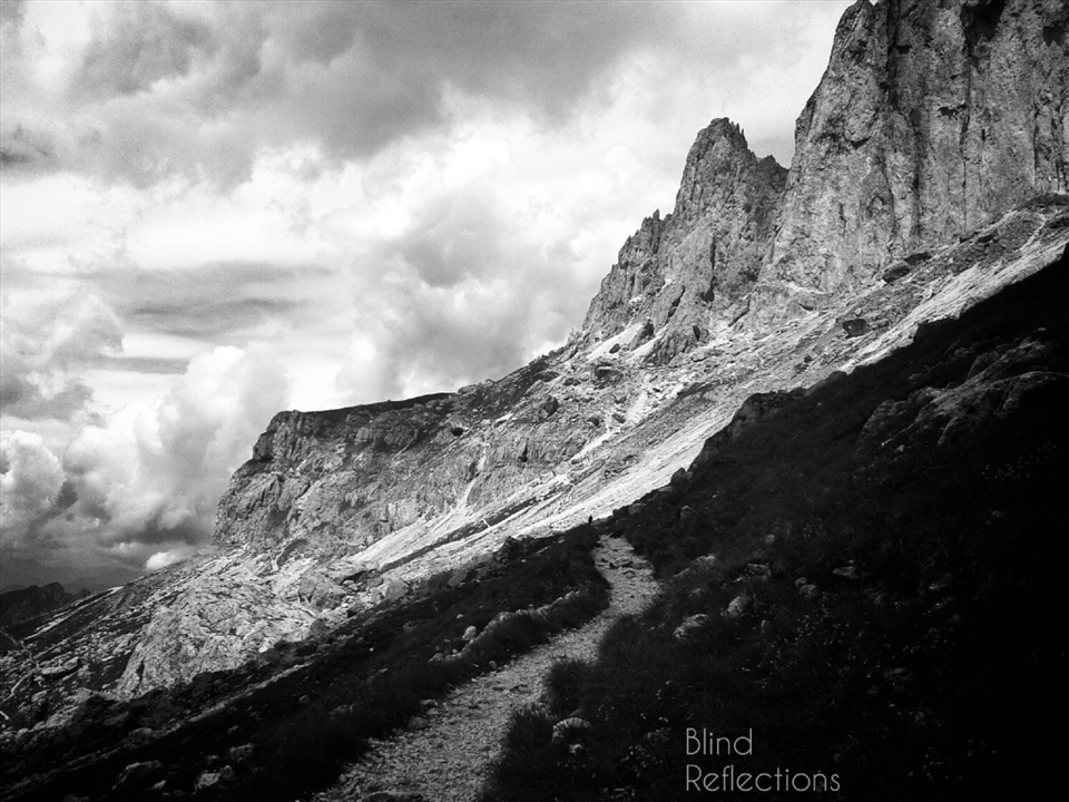 Imponent Nature - A path leads under the rocky formations of the Catinaccio Group, Dolomiti, Italy. 