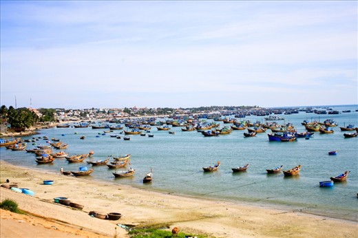 The peaceful coast dotted with a variety of boats for the daily activities the sleepy beach town, Mui Ne.  