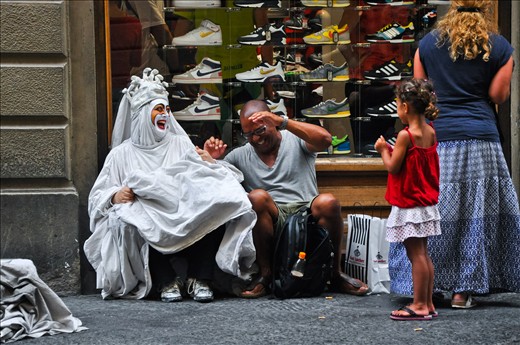 A street artist had enough of it and decided to have some fun with a man that just got out of the shoe store. He was taking a break from shopping and she saw an opportunity to have some fun. They didn't speak the same language but laughter feels and means the same all around the world.