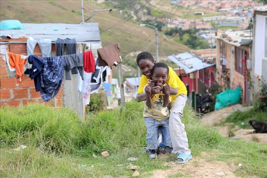Walking along the unpaved roads and uncut grass of this impoverished neighborhood, it is not uncommon to see children playing and laughing with their friends.  
