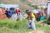Walking along the unpaved roads and uncut grass of this impoverished neighborhood, it is not uncommon to see children playing and laughing with their friends.  : by bogota, Views[353]
