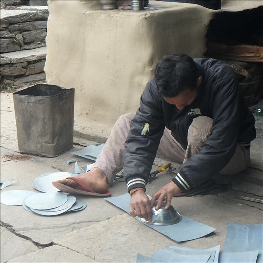 Dinesh using a bowl as a template for metal circles.