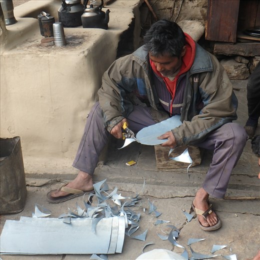 Digember working on a tin circle.