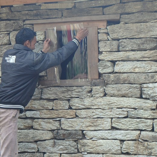 Dinesh about to nail on the window plasic at Saraswati's house.