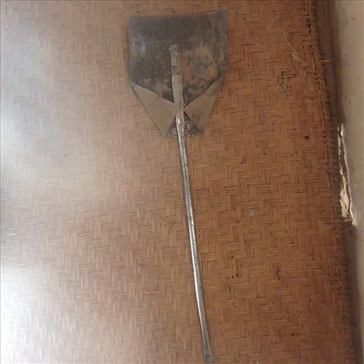 An enterprising villager made this implement to clean out their stove from scrap metal (veg oil can etc).