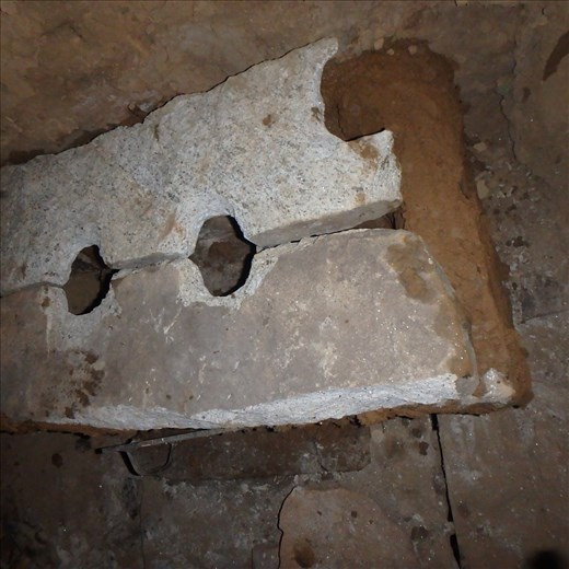 Two holes have been fashioned in a sedimentary rock stone slab that is the stove top. They will be used for cooker, pots, kettle etc.