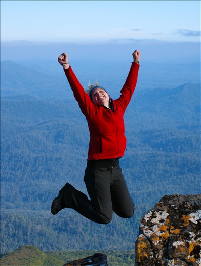 Australian student Katie leaps with joy at the 1300m summit of Mt Weld!