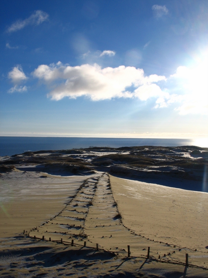 Lithuanians have a myth that the Curonian Spit was created by a giantess named Neringa who was playing on the seashore as a child. The landmass is isolated by the Baltic Sea, Curonian Lagoon and Russian Federation. Nida is the focal point of the 'Spit; a town Flocked to by, up to, a hundred thousand tourists in the summer and populated by about fifteen hundred locals in the winter. on the outskirts of the town are the Dunes which have the aesthetic feel of a stereotypical desert.

*The image is of the Parnidis Dune which continuously threatened the village, with drifting sand, until the village was moved farther away, to its current position, in the 1730s. Beneath the sand lies previous incarnations of the town of Nida.