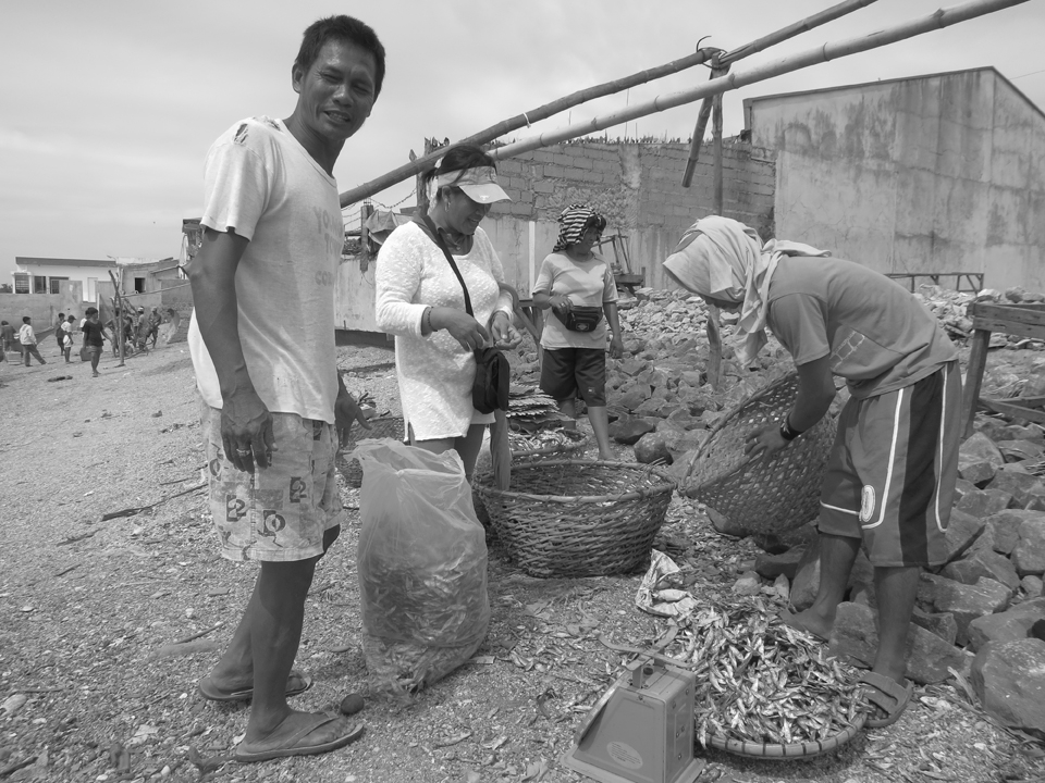 In a small fishing village in the Philippines, a dried fish vendor  started to prep for his day when customers are already asking for details about the goods he is selling. It is going to be a fast day for him.