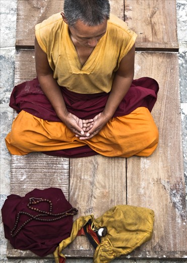 Everyday around the Bouddhanath stupa, monks, nuns, tourists and the ordinary people start their day by practicing Buddhism in different ways. The nun in the picture is meditating after the prostration practice.