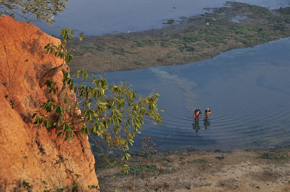 Local tribal immigrate over shallow bed of river 