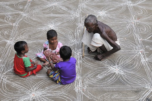 The grandfather shares his merry moments with grandchildren during evening time.