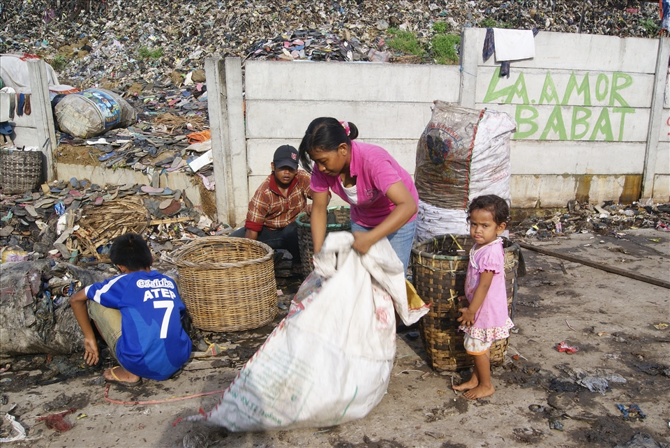 Like brick, stone, cement and other building material connected each other to create sole strong house, so do a father, his wife, son and two-year old young daughter have to gather the “fresh” rubbish and carry it to the nearest fence. This photo was taken at 6.30 am in the early morning reflecting the hard work of the rigid solid family supporting each other and working hand in hand agreed to make a living together, in this rare slum area. 