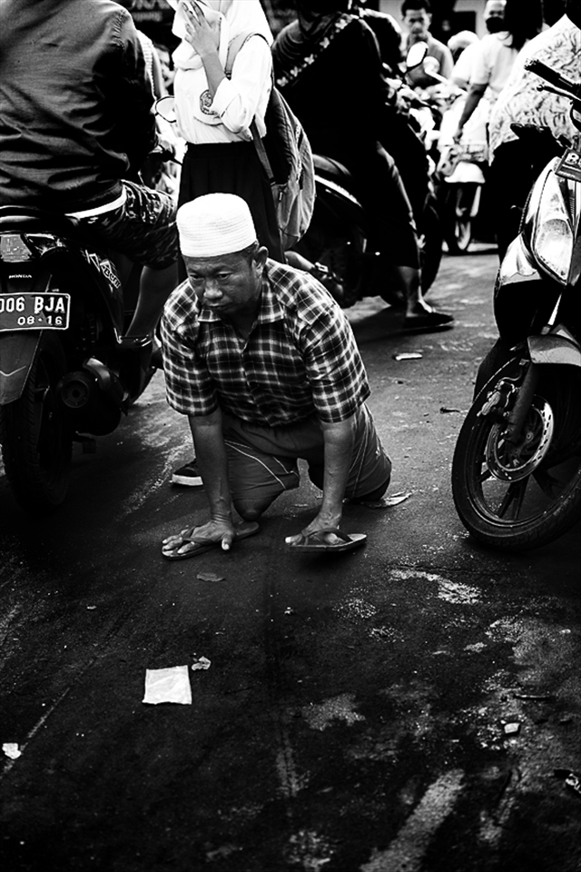 An amputee crawls through traffic after losing his legs in a train accident.