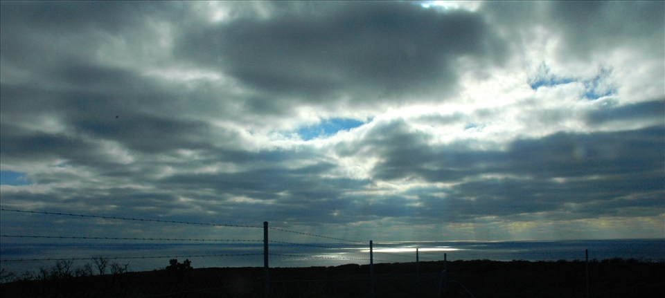 Nature is fenced off and distanced to us. Natural 'god rays' kiss the water, yet