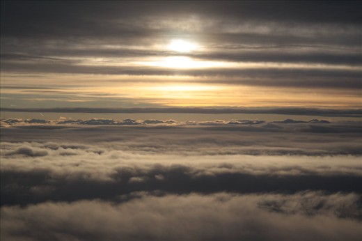 The sun setting in the clouds above Christchurch, Canterbury, NZ, as I descend in a plane. You might not guess that this was simply taken through the porthole window. This photo was taken before the first quakes in Chch. The plane descent is symbolic of the fall of the city and it's most beautiful buildings. The absence of any structures in this image is important also, showing that Chch doesn't need those buildings to be beautiful.