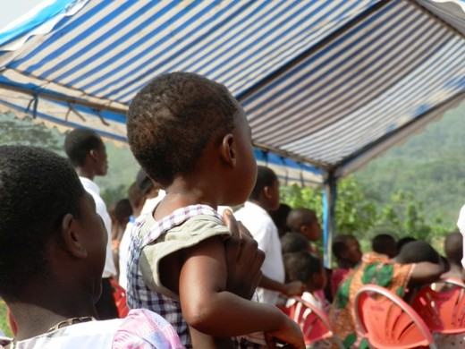 The liitle boy was raised up to catch a glimpse of what was going on.