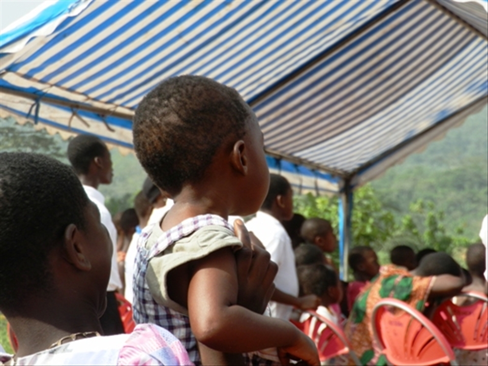 The liitle boy was raised up to catch a glimpse of what was going on.