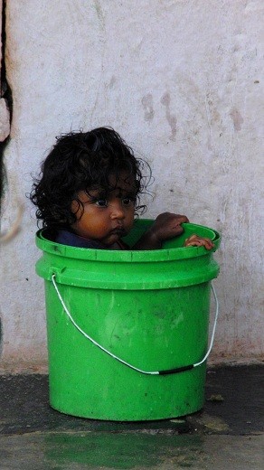 Little girl in a green bucket. Everybody needs to be proper.