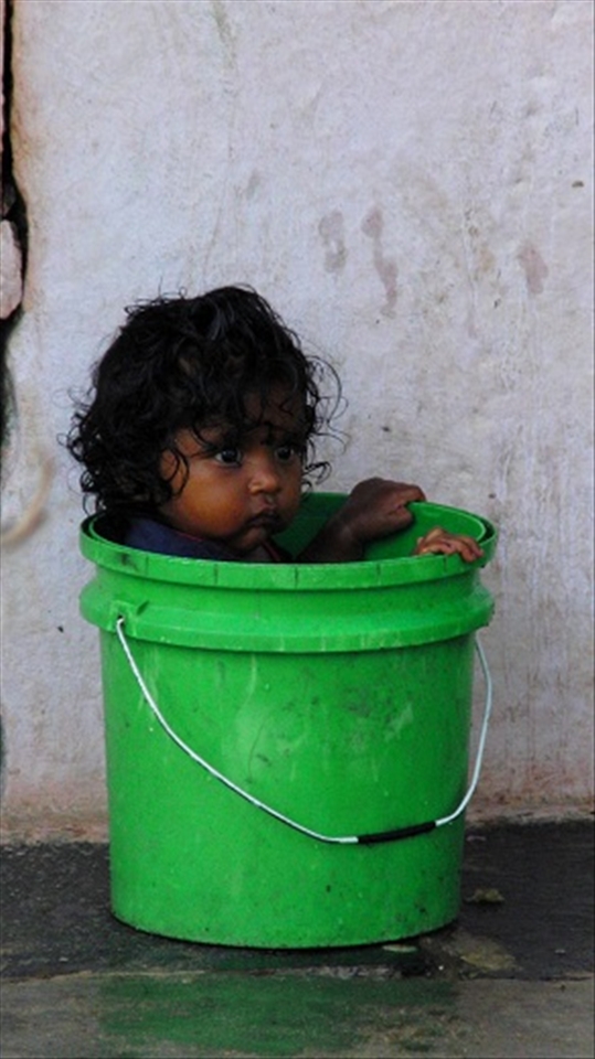 Little girl in a green bucket. Everybody needs to be proper.
