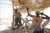 Sheltered from the noon sun, Pedro fixes the new holes in his fishing net : by brittbasel, Views[403]