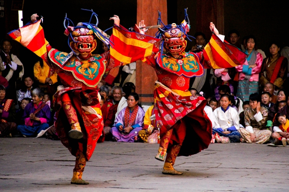 Local Dance - The locals, as seen in the background, attend the festival in their finest clothes - the brightly coloured silk Kira for the women and the Gho for the men. The dancing at the festivals is enegetic and hypnotic.