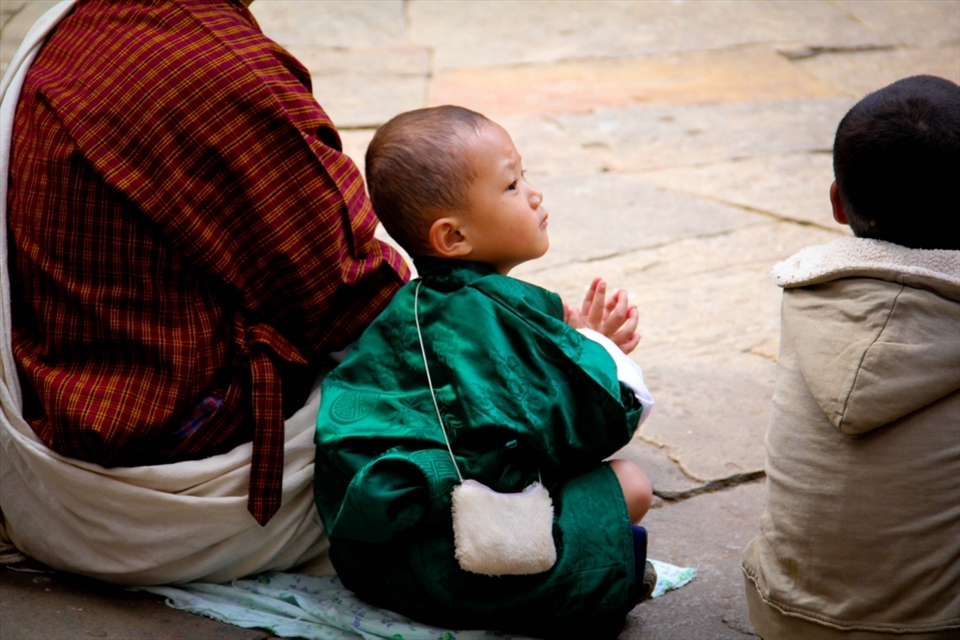 Prayer - A child claspes her hands together in Buddhist prayer. Bhutan is the only country in the world with a Buddhist government and prayer is a part of everyday life.