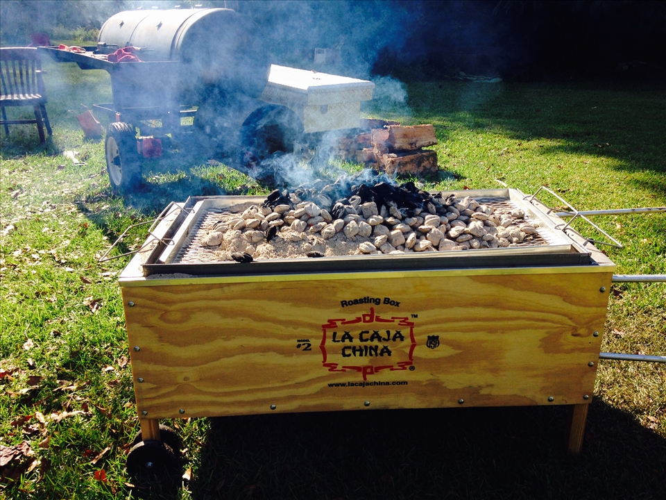 Caja china with coals on top and hog inside. 