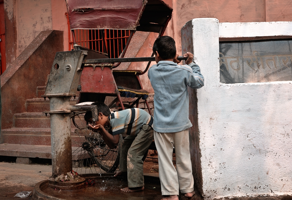 Teamwork. A boy receives a helping hand to get a drink of water, for locals only