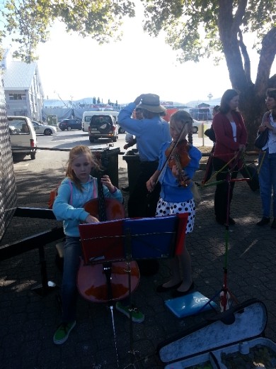 A couple of young girls busking for the crowd at the markets