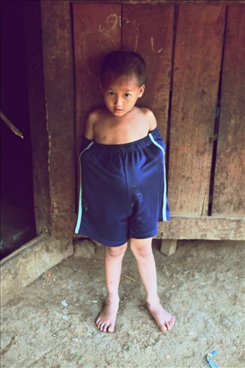 Khmu boy. Laos. Step out of the house