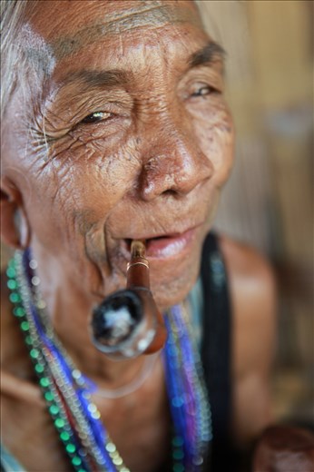 Laven woman. Laos. Pipe smoking on the porch