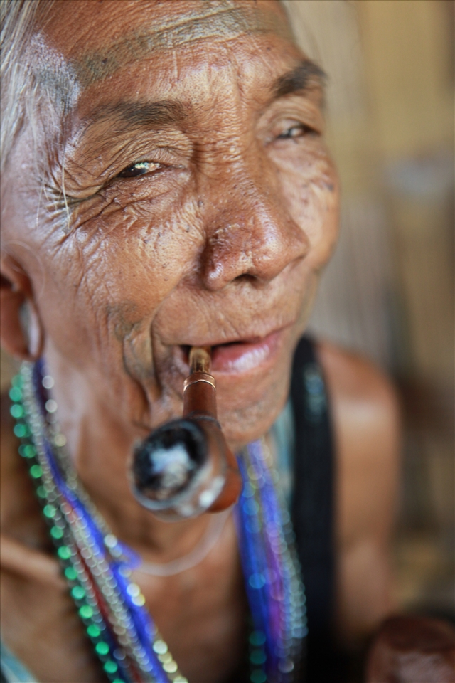 Laven woman. Laos. Pipe smoking on the porch